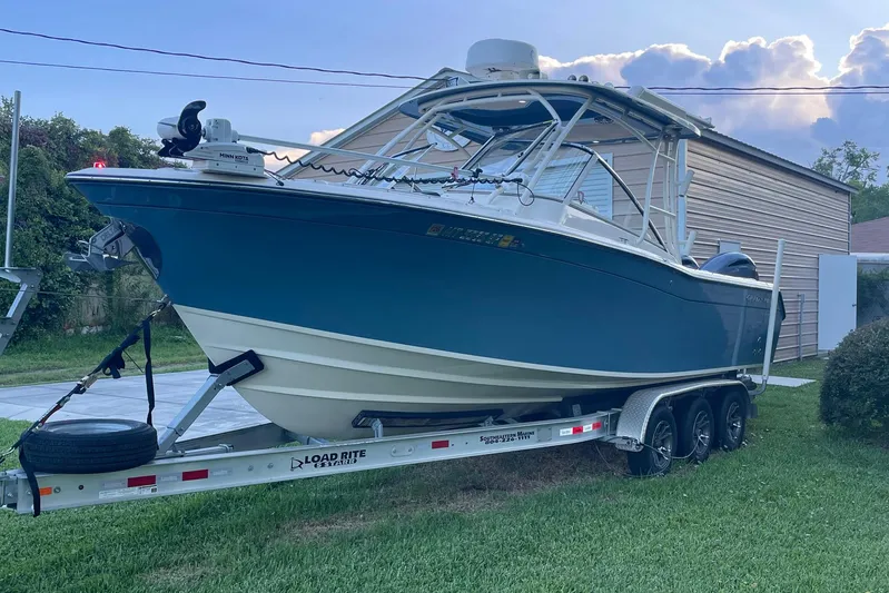  Yacht Photos Pics 2021 Grady-White Freedom 275 boat on trailer, parked in a grassy yard.