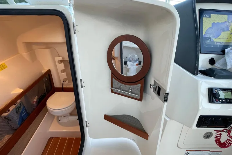  Yacht Photos Pics 2021 Grady-White Freedom 275 boat interior with toilet and navigation equipment.