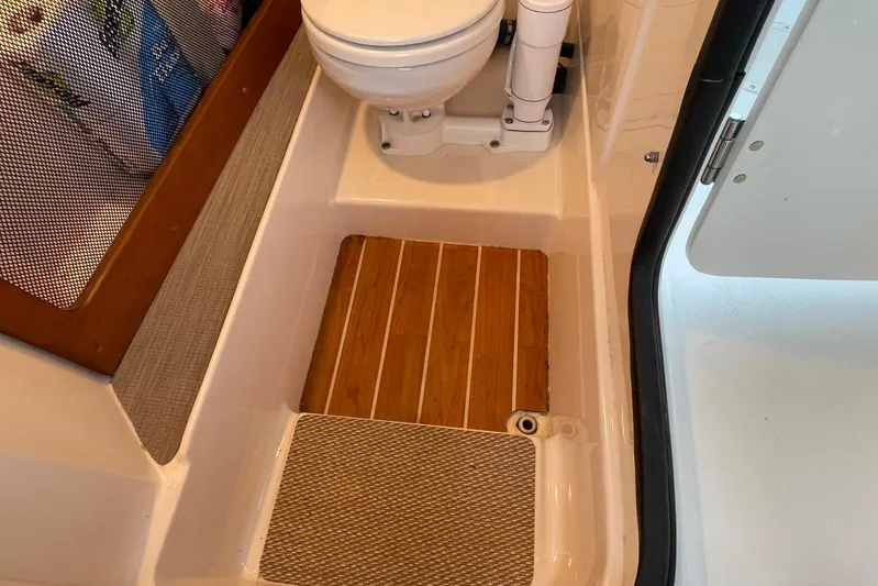  Yacht Photos Pics 2021 Grady-White Freedom 275 boat interior with wooden flooring and compact toilet.