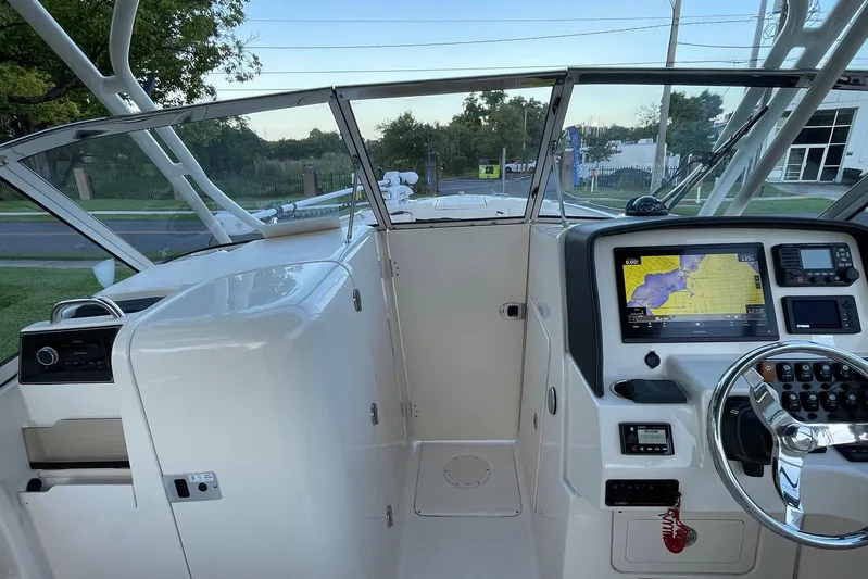  Yacht Photos Pics 2021 Grady-White Freedom 275 boat cockpit with navigation system and steering wheel.