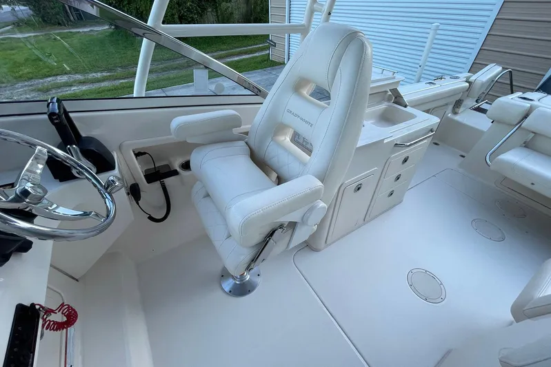 Yacht Photos Pics 2021 Grady-White Freedom 275 boat interior with white captain's chair and steering wheel.