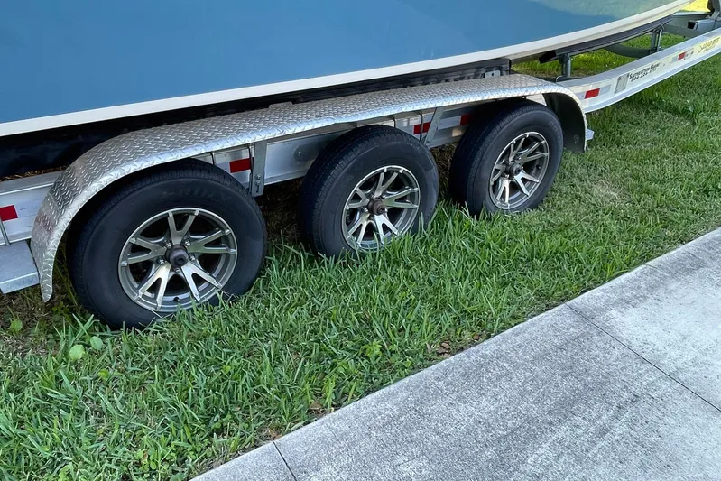  Yacht Photos Pics Trailer with three wheels carrying a 2021 Grady-White Freedom 275 boat.