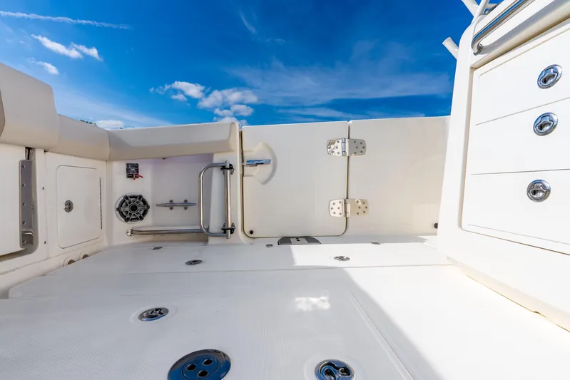 Gugui Yacht Photos Pics 2024 Boston Whaler 420 Outrage deck with storage and seating under clear blue sky.