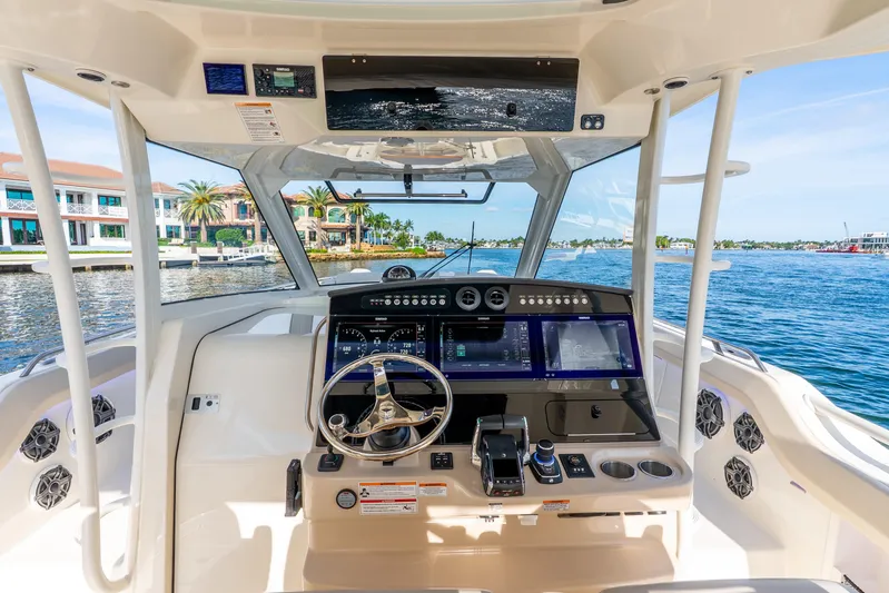 Gugui Yacht Photos Pics 2024 Boston Whaler 420 Outrage helm with advanced navigation system, docked near waterfront homes.