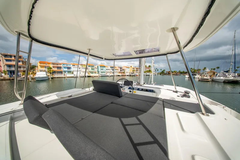 Dakiti Yacht Photos Pics 2023 Lagoon 46 catamaran with spacious deck, docked in a vibrant marina.