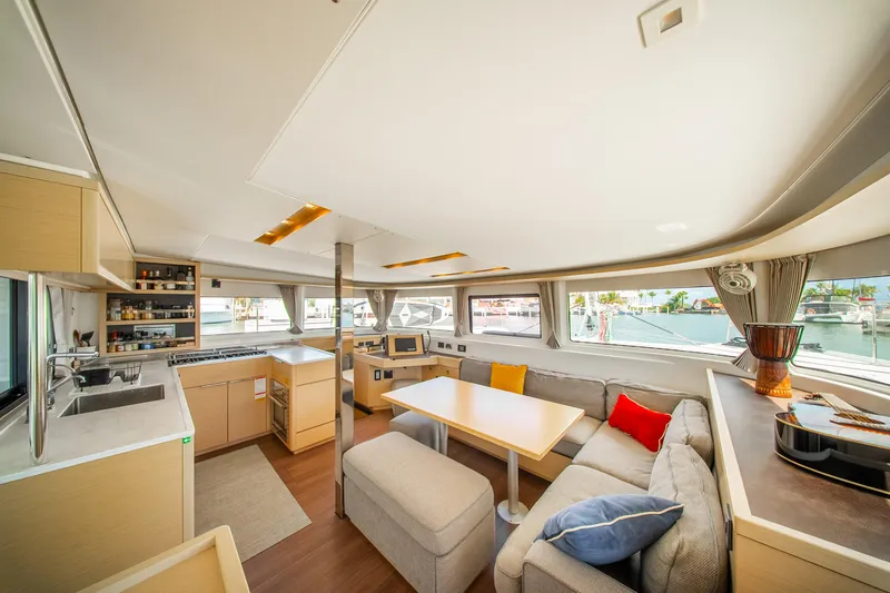 Dakiti Yacht Photos Pics Luxurious interior of 2023 Lagoon 46 catamaran with modern kitchen and cozy seating area.