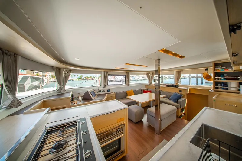 Dakiti Yacht Photos Pics Luxurious interior of 2023 Lagoon 46 yacht, featuring modern kitchen and spacious seating area.