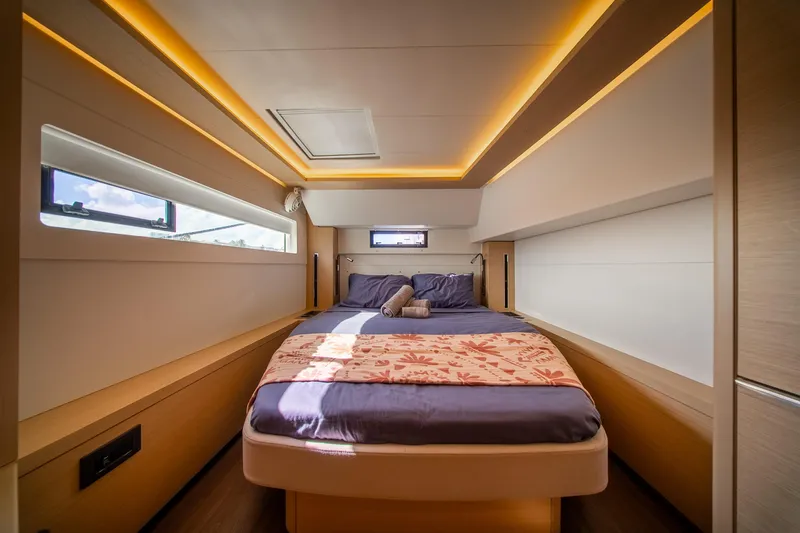Dakiti Yacht Photos Pics Luxurious interior of 2023 Lagoon 46 yacht with cozy bed and ambient lighting.