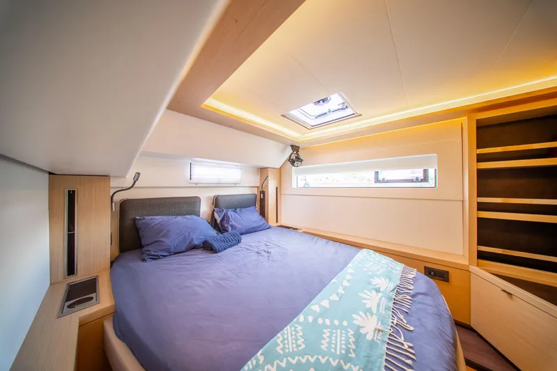 Dakiti Yacht Photos Pics Luxurious bedroom interior of 2023 Lagoon 46 yacht with modern design and ambient lighting.