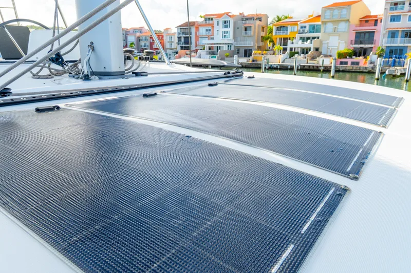 Dakiti Yacht Photos Pics 2023 Lagoon 46 catamaran with solar panels, docked near colorful waterfront homes.