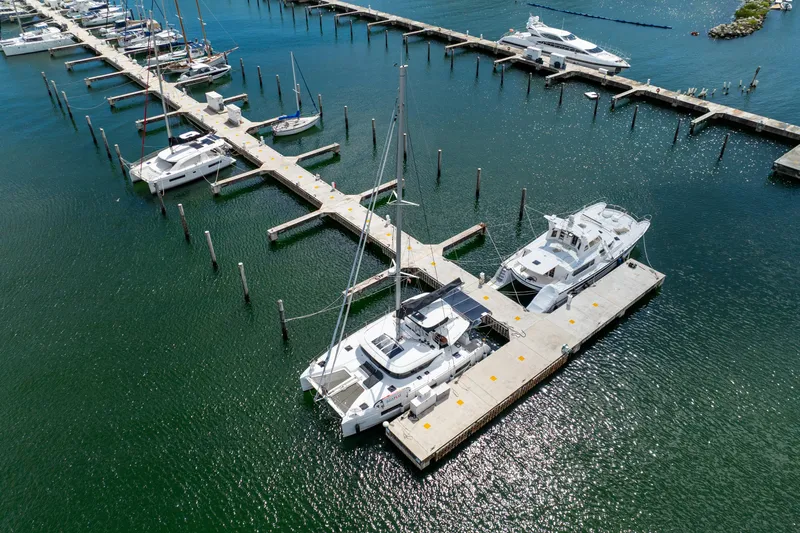 Dakiti Yacht Photos Pics Aerial view of 2023 Lagoon 46 catamaran docked at marina with other boats.