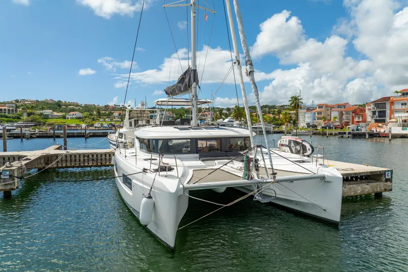 Dakiti Yacht Photos Pics 2023 Lagoon 46 catamaran docked in a scenic marina under a bright blue sky.