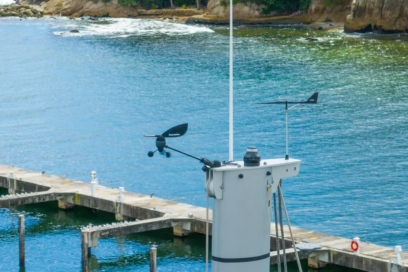 Dakiti Yacht Photos Pics Mast of 2023 Lagoon 46 catamaran with wind instruments, dock, and scenic coastal background.