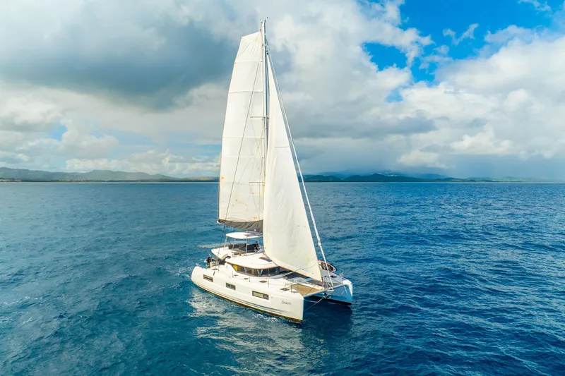 Dakiti Yacht Photos Pics 2023 Lagoon 46 catamaran sailing on open sea under a partly cloudy sky.