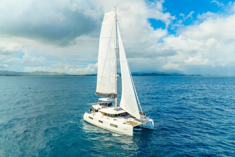 Dakiti Yacht Photos Pics 2023 Lagoon 46 catamaran sailing on open ocean under a partly cloudy sky.