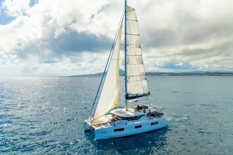 Dakiti Yacht Photos Pics 2023 Lagoon 46 catamaran sailing on open sea under cloudy sky.
