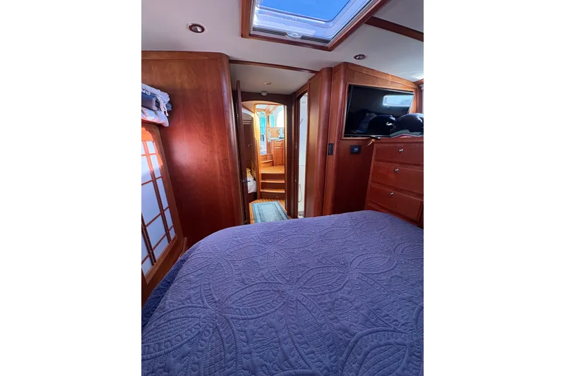  Yacht Photos Pics Interior of 2023 Sabre 45 Salon Express yacht with cozy bedroom and wooden cabinetry.