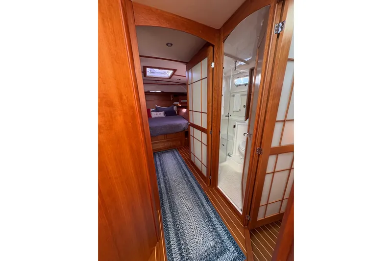  Yacht Photos Pics 2023 Sabre 45 Salon Express interior with wooden doors, cozy bedroom, and modern bathroom.