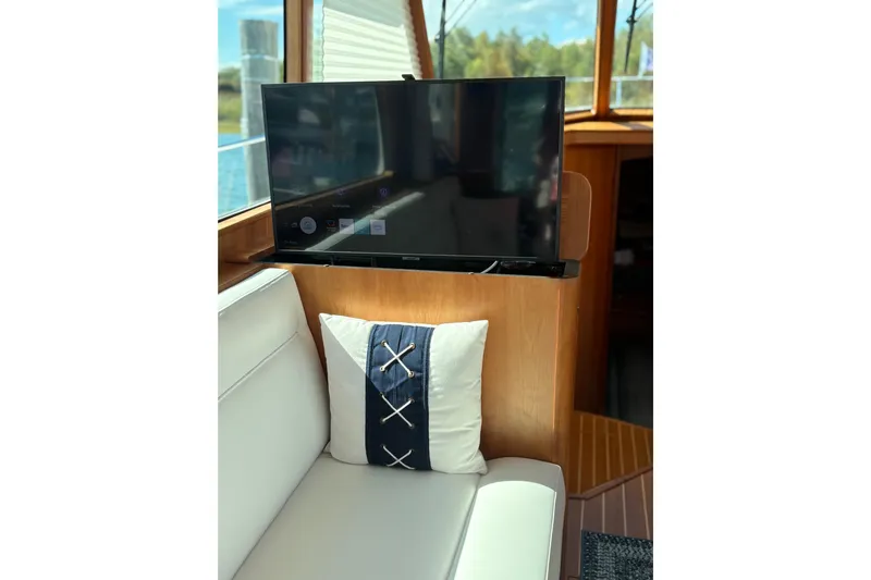  Yacht Photos Pics Interior of 2023 Sabre 45 Salon Express with TV and nautical-themed pillow.