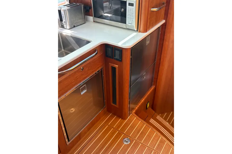 Yacht Photos Pics 2023 Sabre 45 Salon Express galley with wood cabinetry, stainless steel appliances, and modern fixtures.