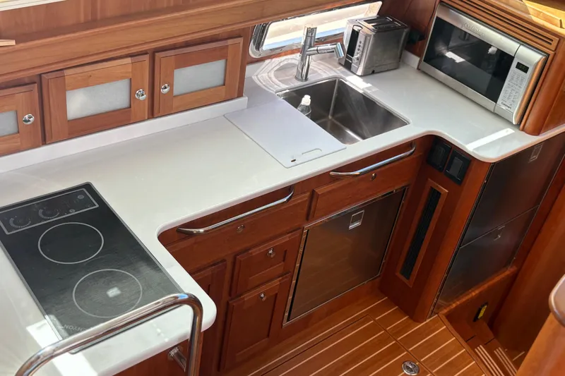  Yacht Photos Pics Modern kitchen in 2023 Sabre 45 Salon Express yacht with stove, sink, and microwave.