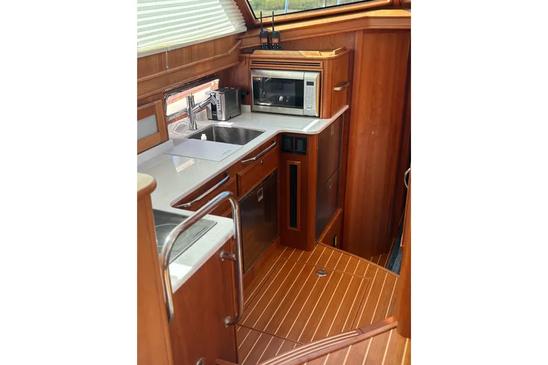  Yacht Photos Pics Luxurious 2023 Sabre 45 Salon Express yacht kitchen with modern appliances and wood finish.