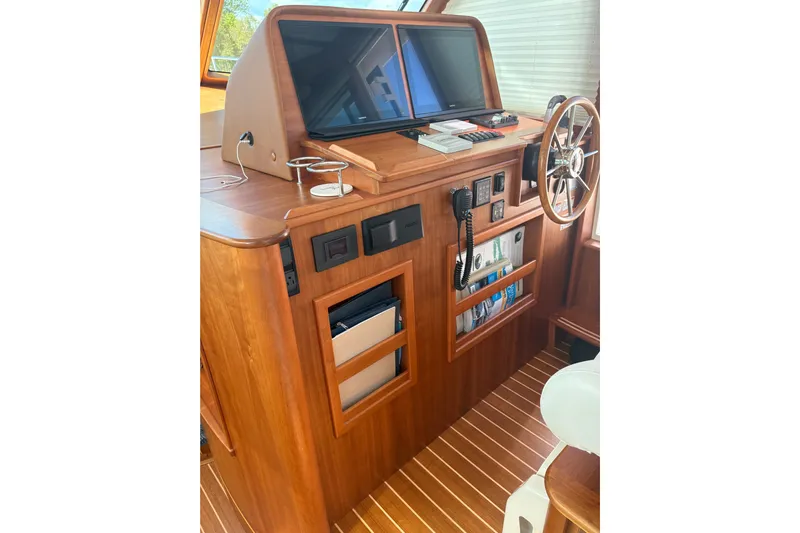  Yacht Photos Pics 2023 Sabre 45 Salon Express helm with wooden finish and modern navigation equipment.
