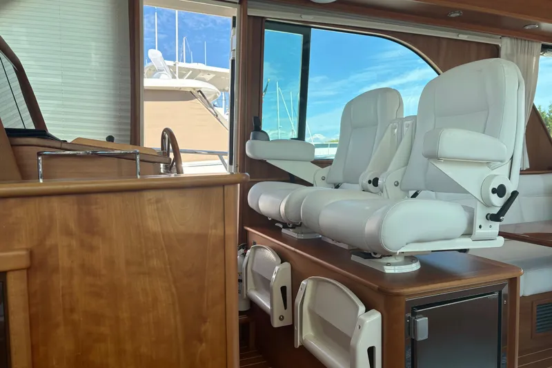  Yacht Photos Pics Interior of 2023 Sabre 45 Salon Express with white captain chairs and wooden finishes.