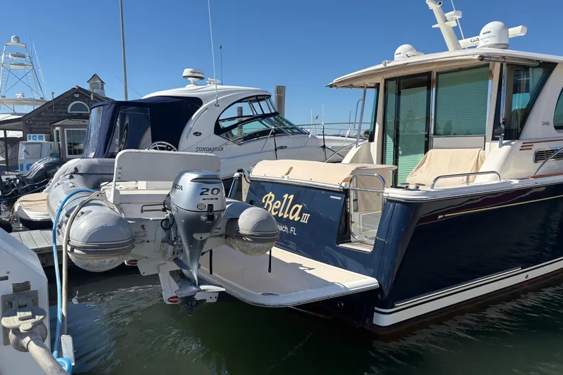  Yacht Photos Pics 2023 Sabre 45 Salon Express yacht docked with inflatable boat attached.