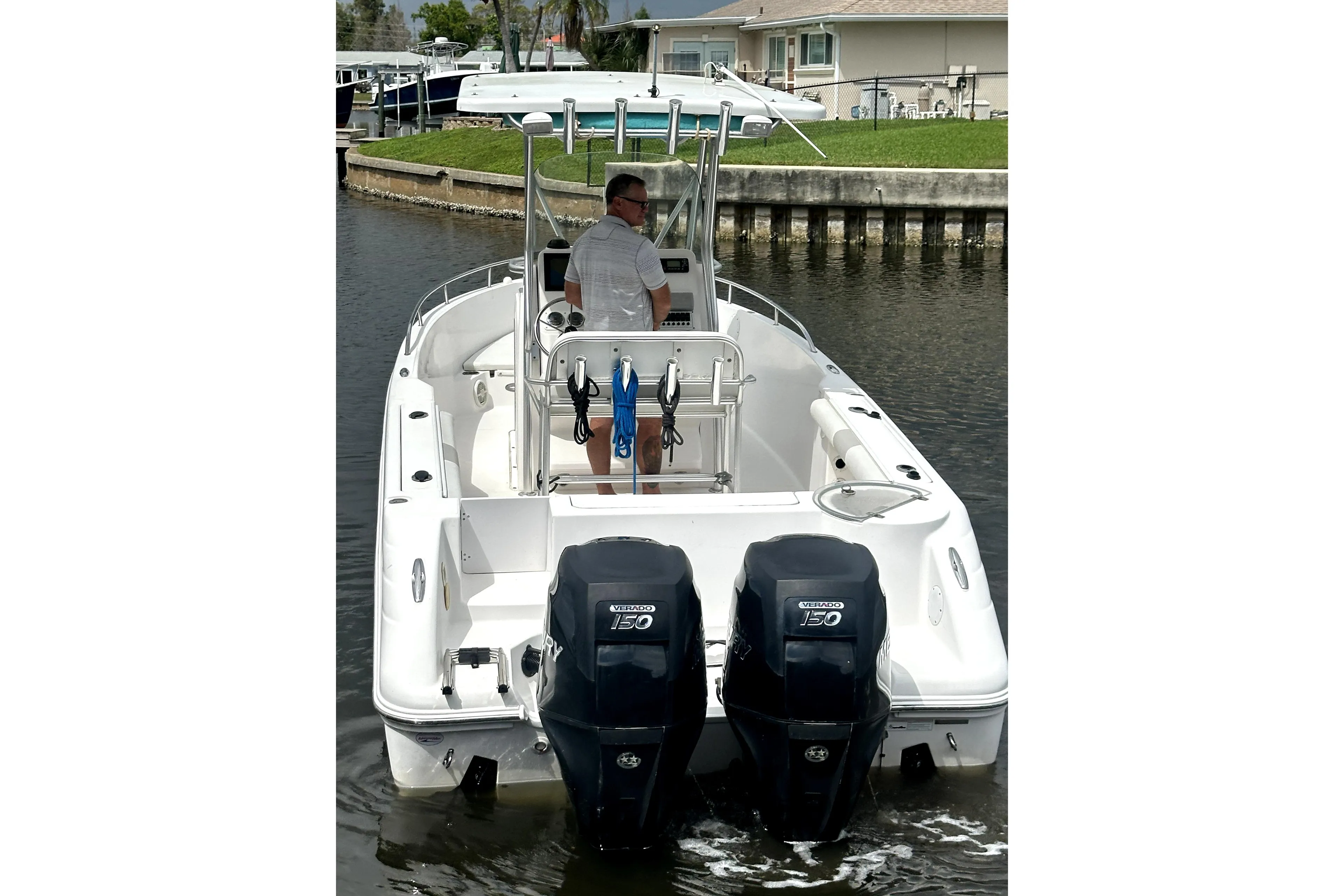 2014 Pro-Line 26 Super Sport boat with dual outboard engines on a calm waterway.