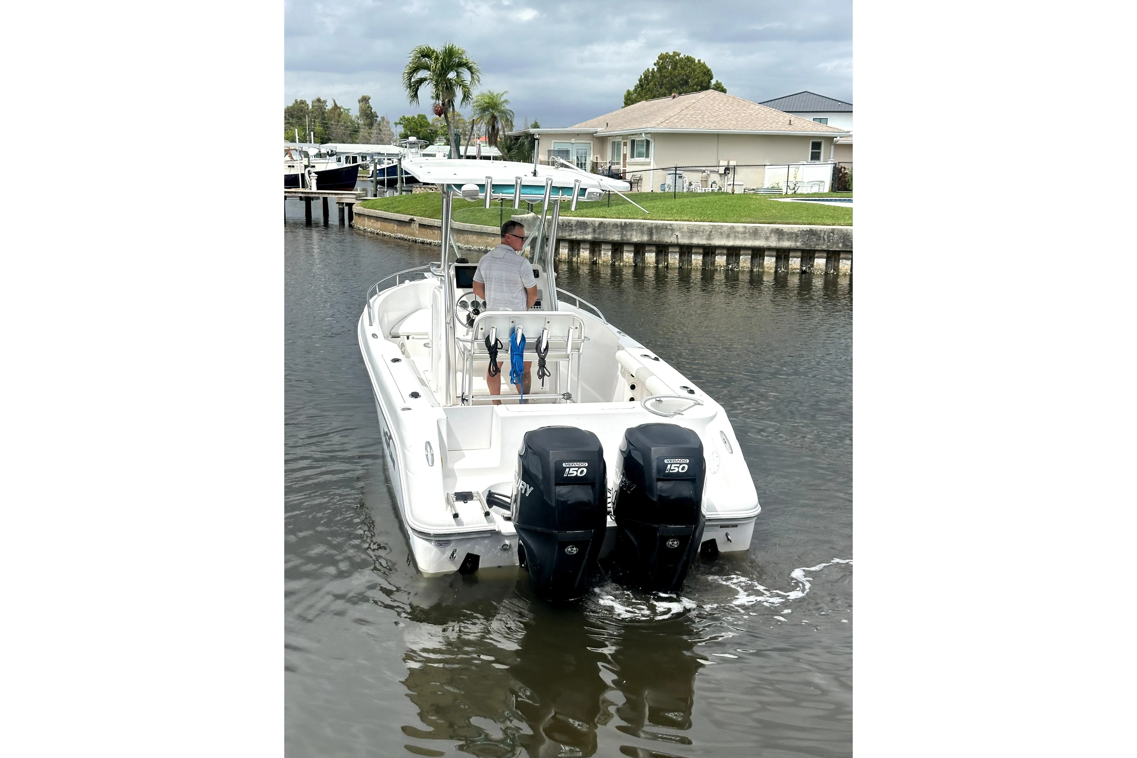 2014 Pro-Line 26 Super Sport boat with dual engines on a calm waterway.