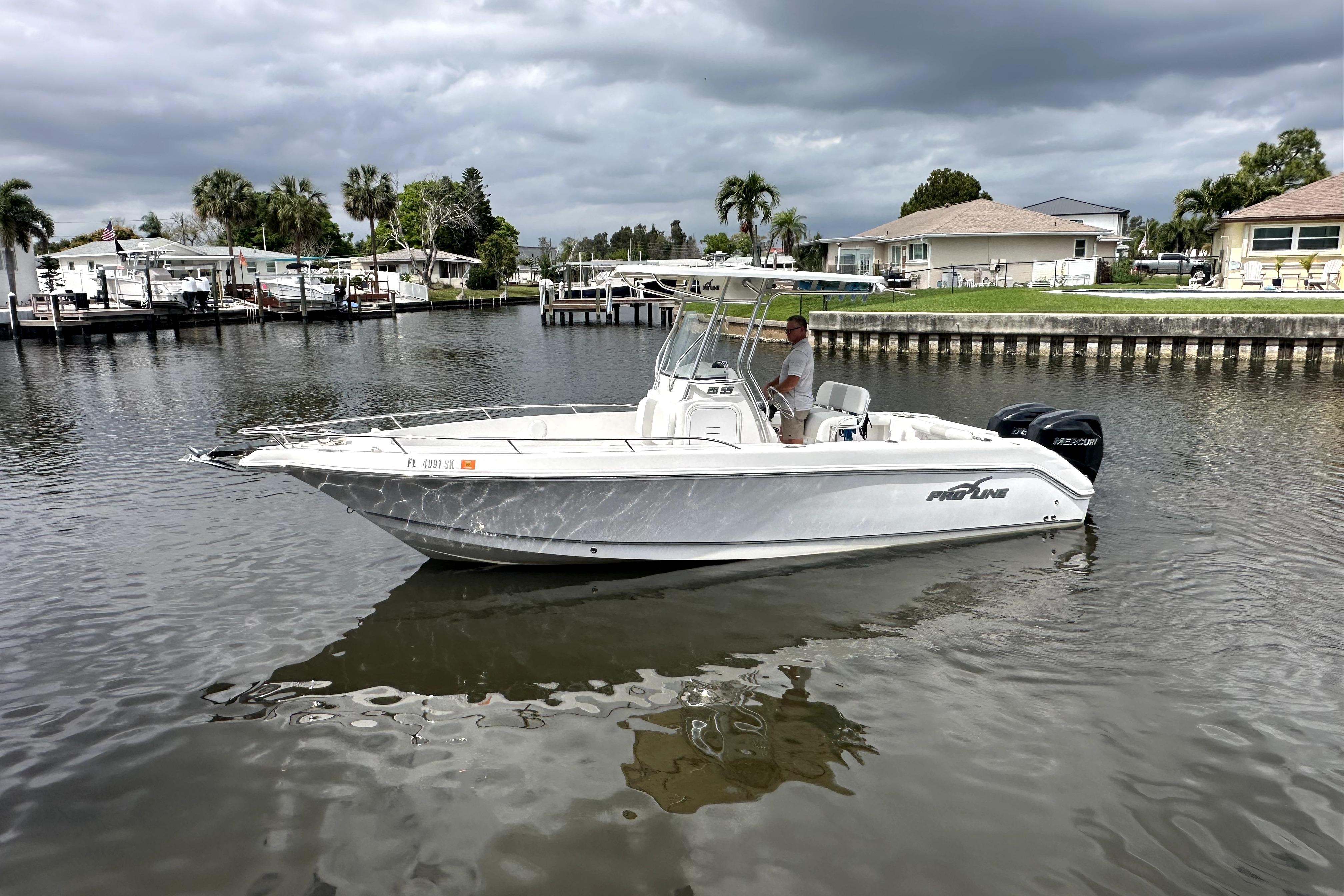2014 Pro-Line 26 Super Sport boat on calm water, cloudy sky background.