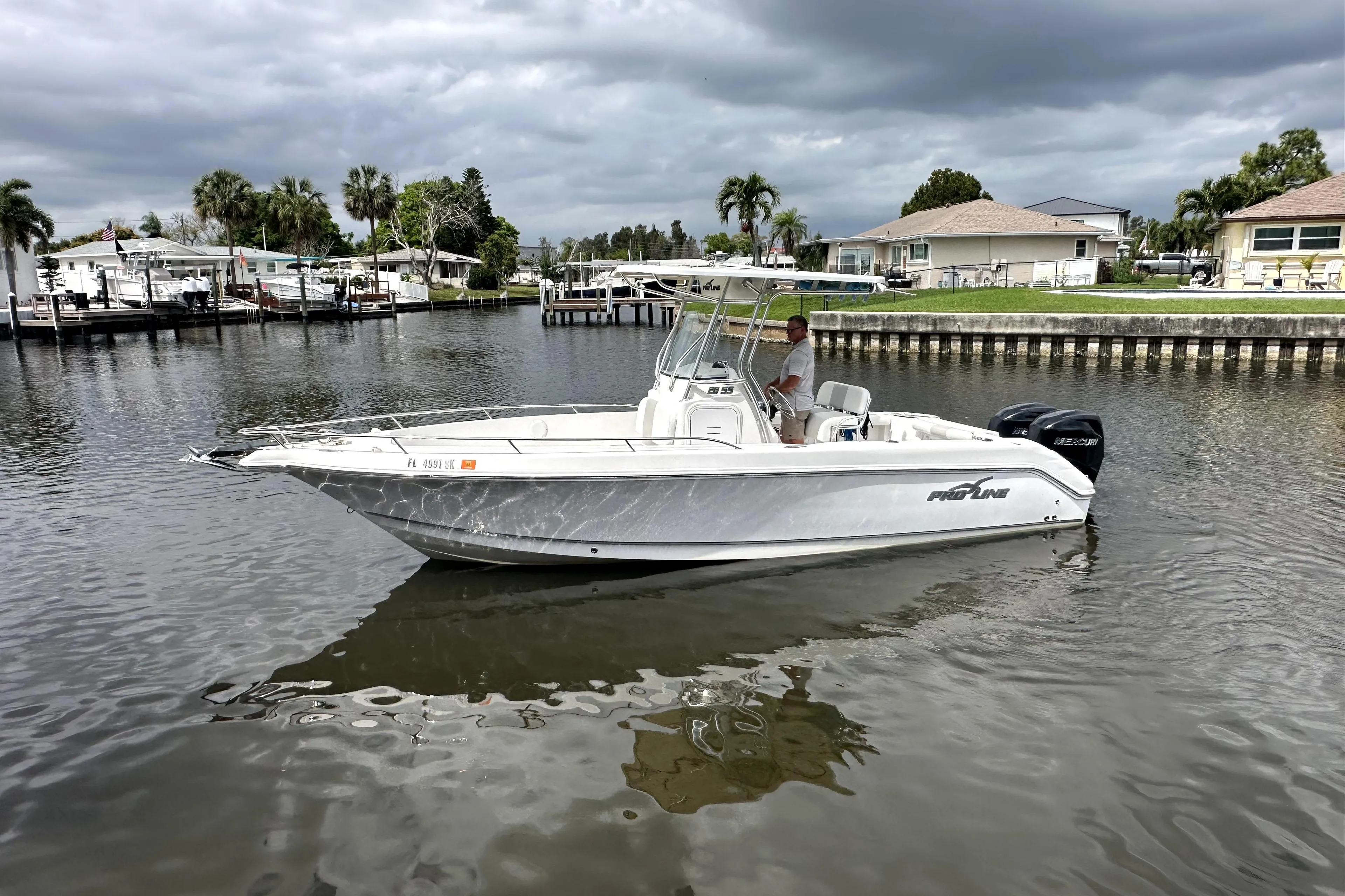 2014 Pro-Line 26 Super Sport boat on calm water, cloudy sky background.