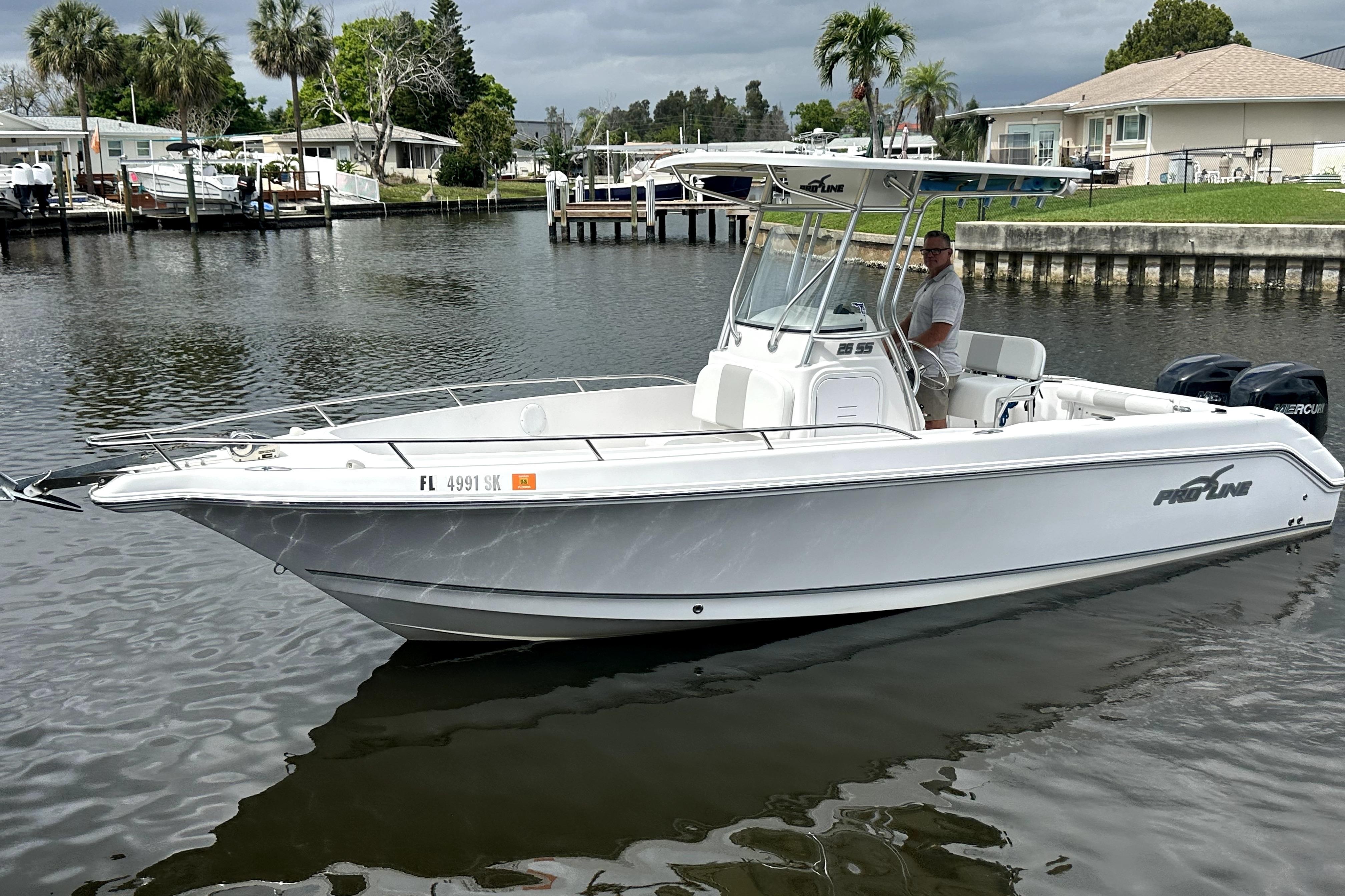 2014 Pro-Line 26 Super Sport boat on calm water, featuring sleek design and modern amenities.