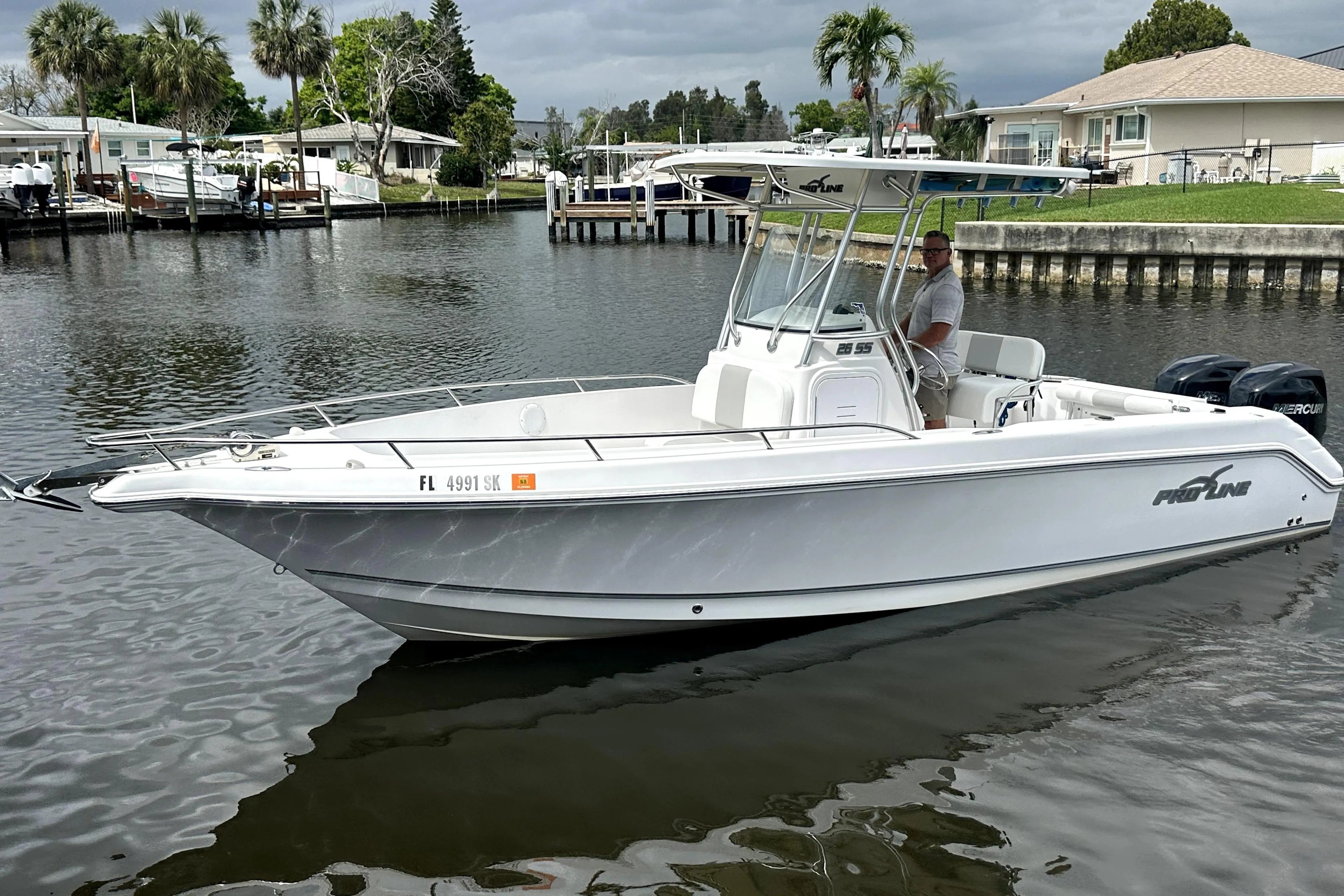 2014 Pro-Line 26 Super Sport boat on calm water, featuring sleek design and modern amenities.