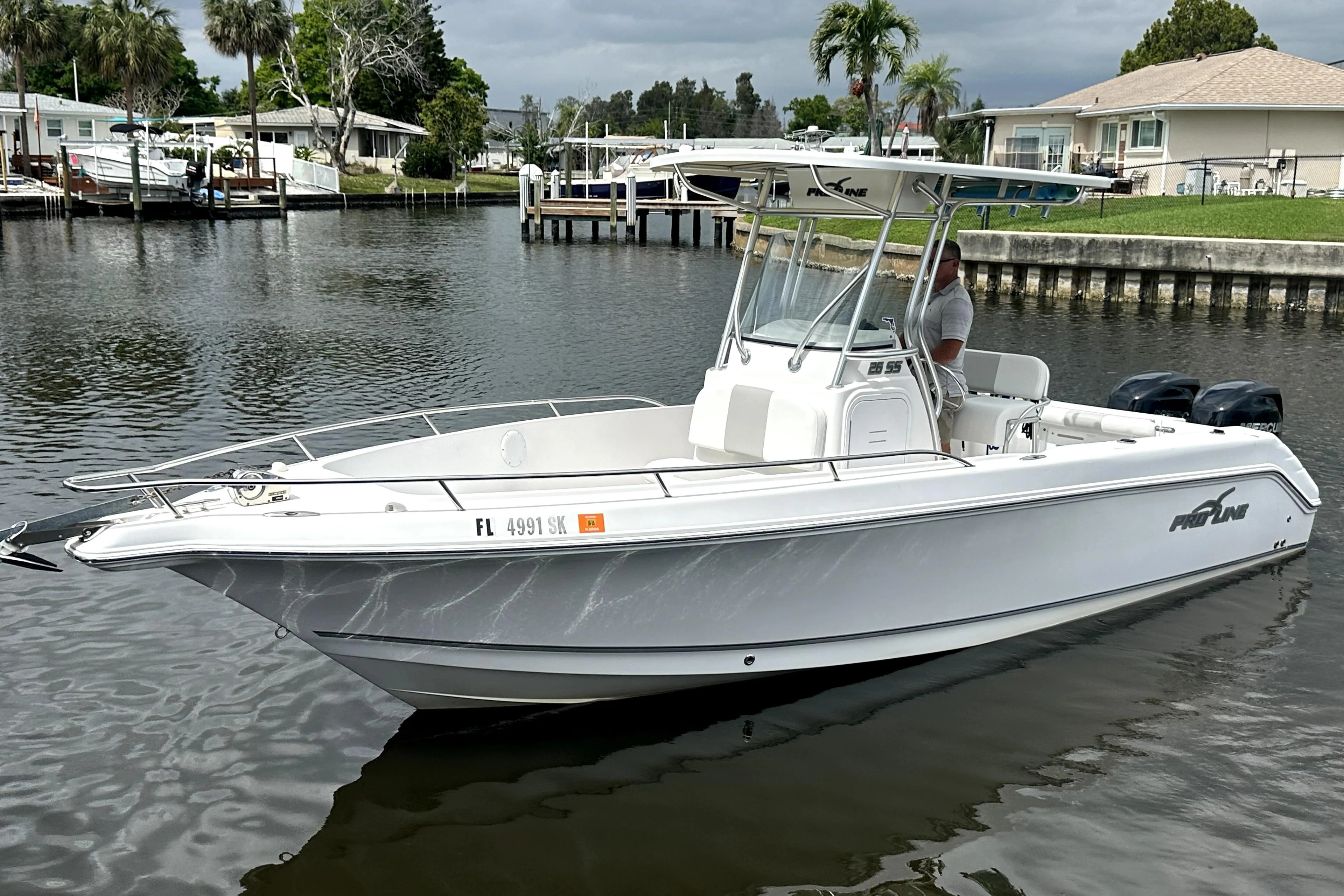 2014 Pro-Line 26 Super Sport boat on calm water, dockside view.