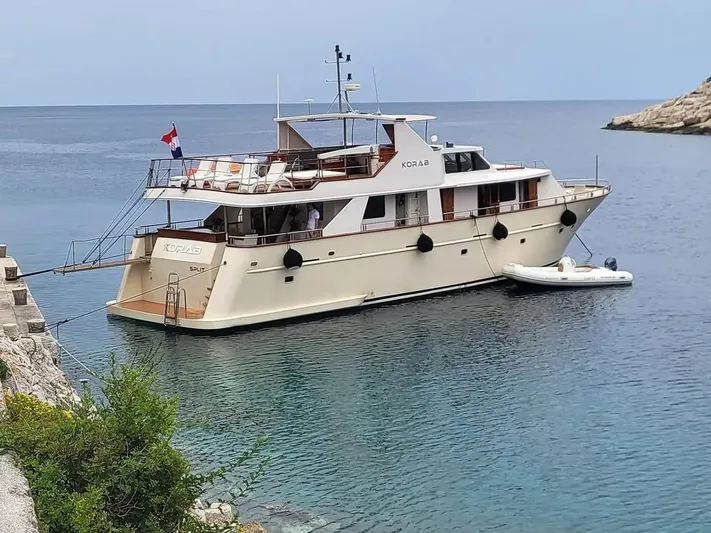 Korab Yacht Photos Pics Custom Motor Yacht Korab, 2001, docked in a serene coastal setting.