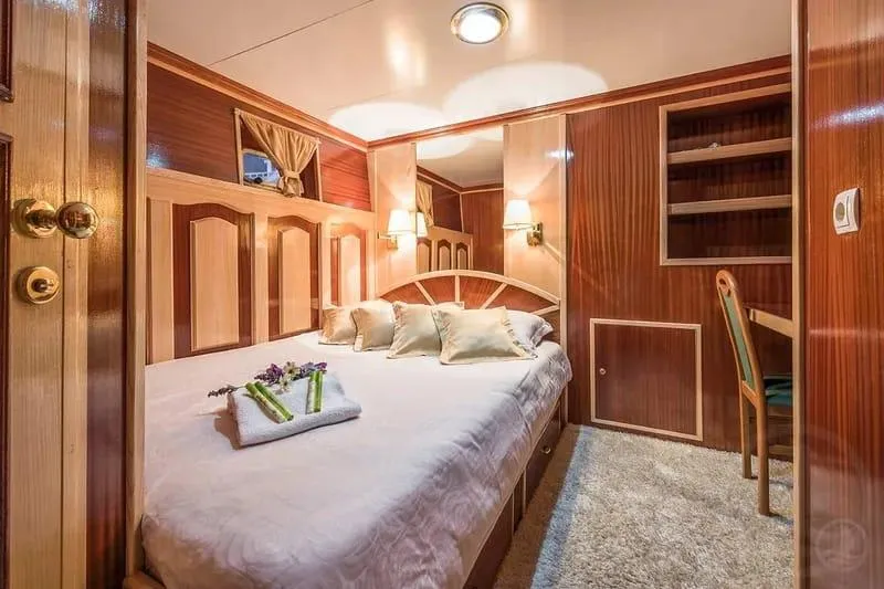 Korab Yacht Photos Pics Luxurious cabin interior of 2001 Custom Motor Yacht Korab with elegant wood paneling and cozy bedding.