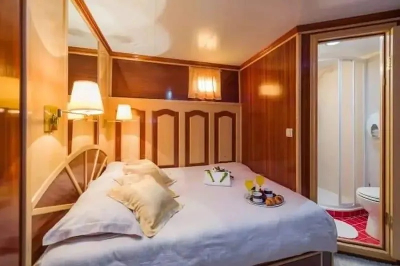 Korab Yacht Photos Pics Luxurious bedroom on Motor Yacht Korab, 2001, featuring elegant wood paneling and ensuite bathroom.