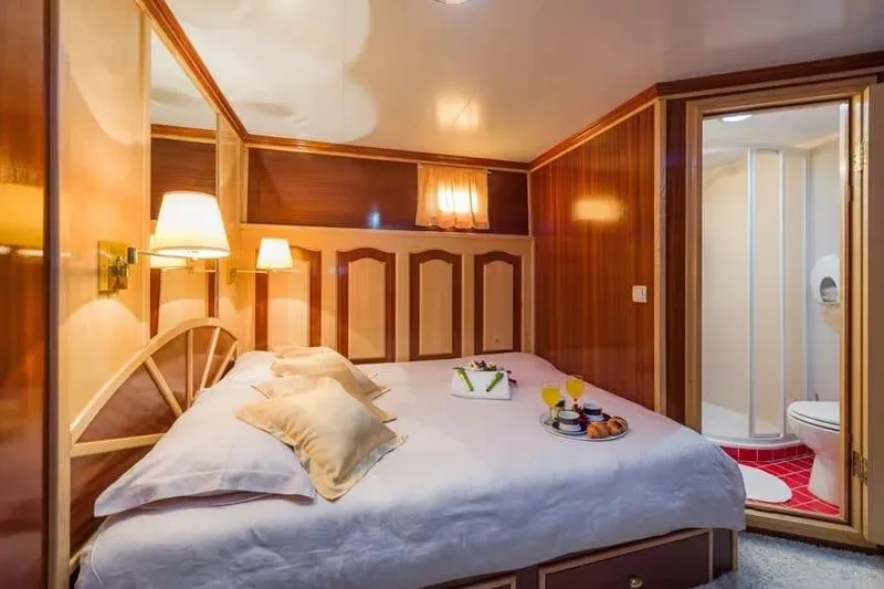 Korab Yacht Photos Pics Luxurious bedroom on Motor Yacht Korab, featuring elegant wood paneling and ensuite bathroom.
