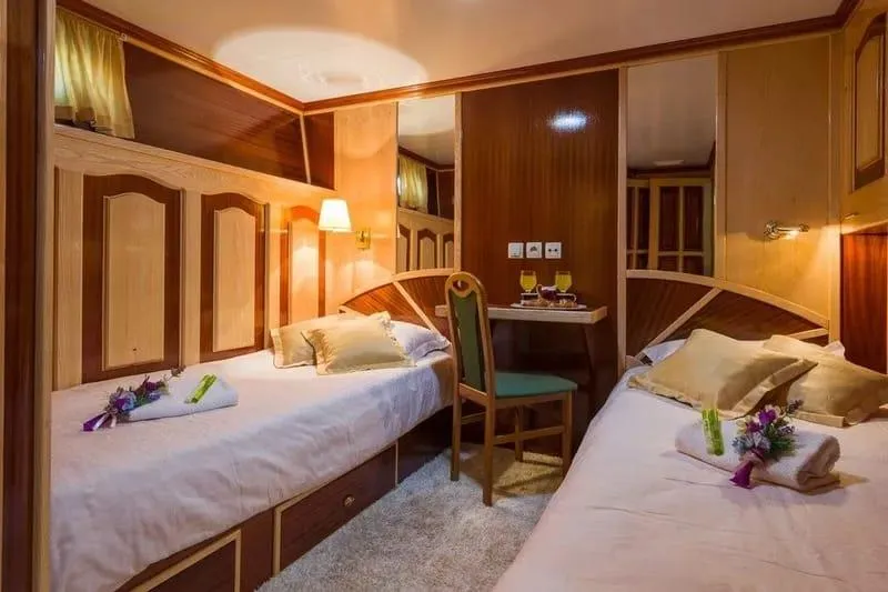 Korab Yacht Photos Pics Luxurious twin cabin on Motor Yacht Korab, 2001, featuring elegant wood paneling and cozy bedding.