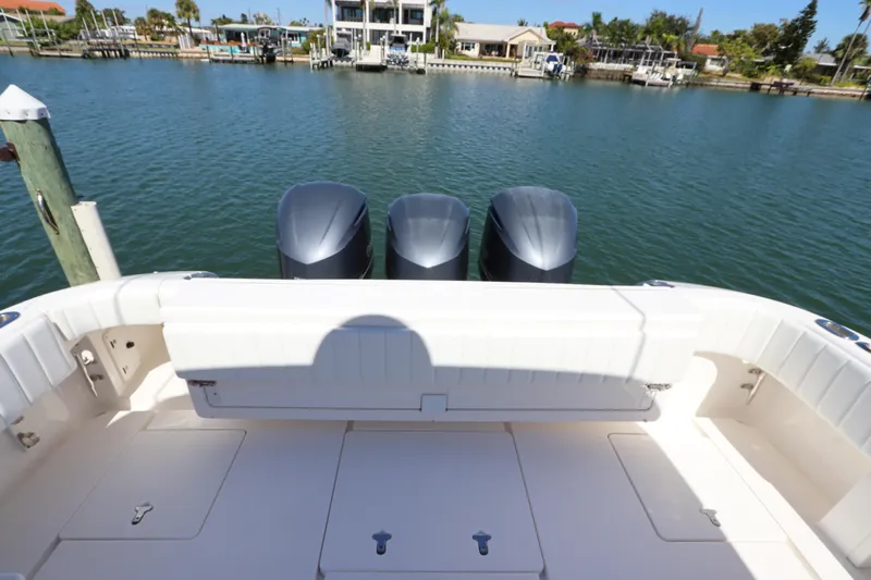 Relentless Yacht Photos Pics 2012 Intrepid 430 Sport Yacht with triple outboard engines, docked by waterfront homes.