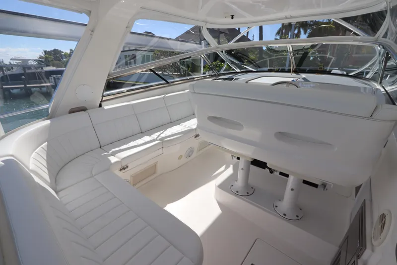 Relentless Yacht Photos Pics 2012 Intrepid 430 Sport Yacht interior with white seating and helm, docked by the water.