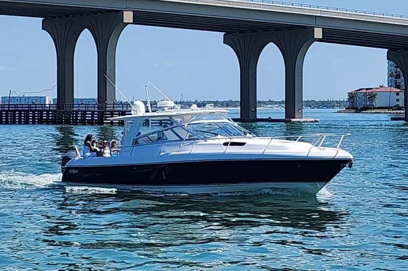 Relentless Yacht Photos Pics 2012 Intrepid 430 Sport Yacht cruising under a bridge on a sunny day.
