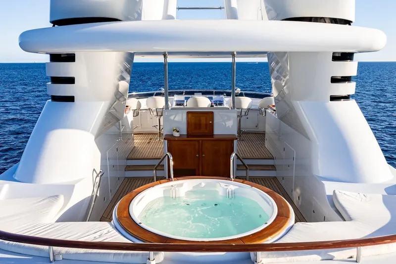 Mystique Yacht Photos Pics Luxurious 2001 Feadship Custom yacht with jacuzzi, overlooking serene ocean waters.