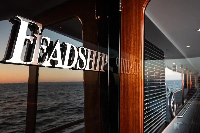 Mystique Yacht Photos Pics Feadship Custom yacht, 2001 model, reflecting sunset on polished wood exterior.