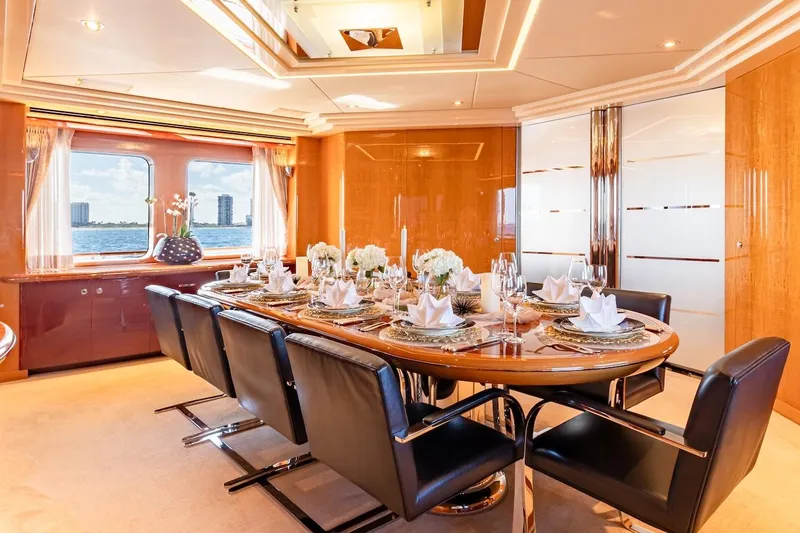 Mystique Yacht Photos Pics Luxurious dining area on 2001 Feadship Custom yacht, elegantly set table with ocean view.
