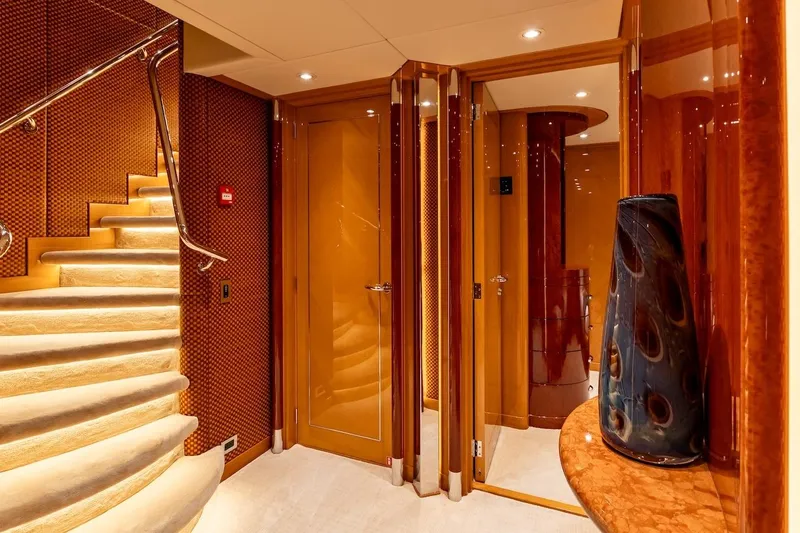 Mystique Yacht Photos Pics Luxurious interior of 2001 Feadship Custom yacht with elegant staircase and polished wood finishes.