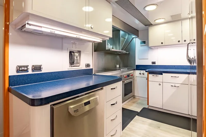 Mystique Yacht Photos Pics Luxurious yacht kitchen with modern appliances, blue countertops, and sleek cabinetry, Feadship Custom 2001.