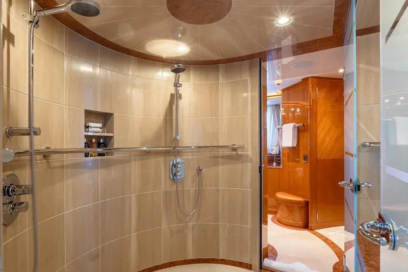 Mystique Yacht Photos Pics Luxurious yacht bathroom with curved shower, elegant wood accents, and modern fixtures, Feadship Custom 2001.
